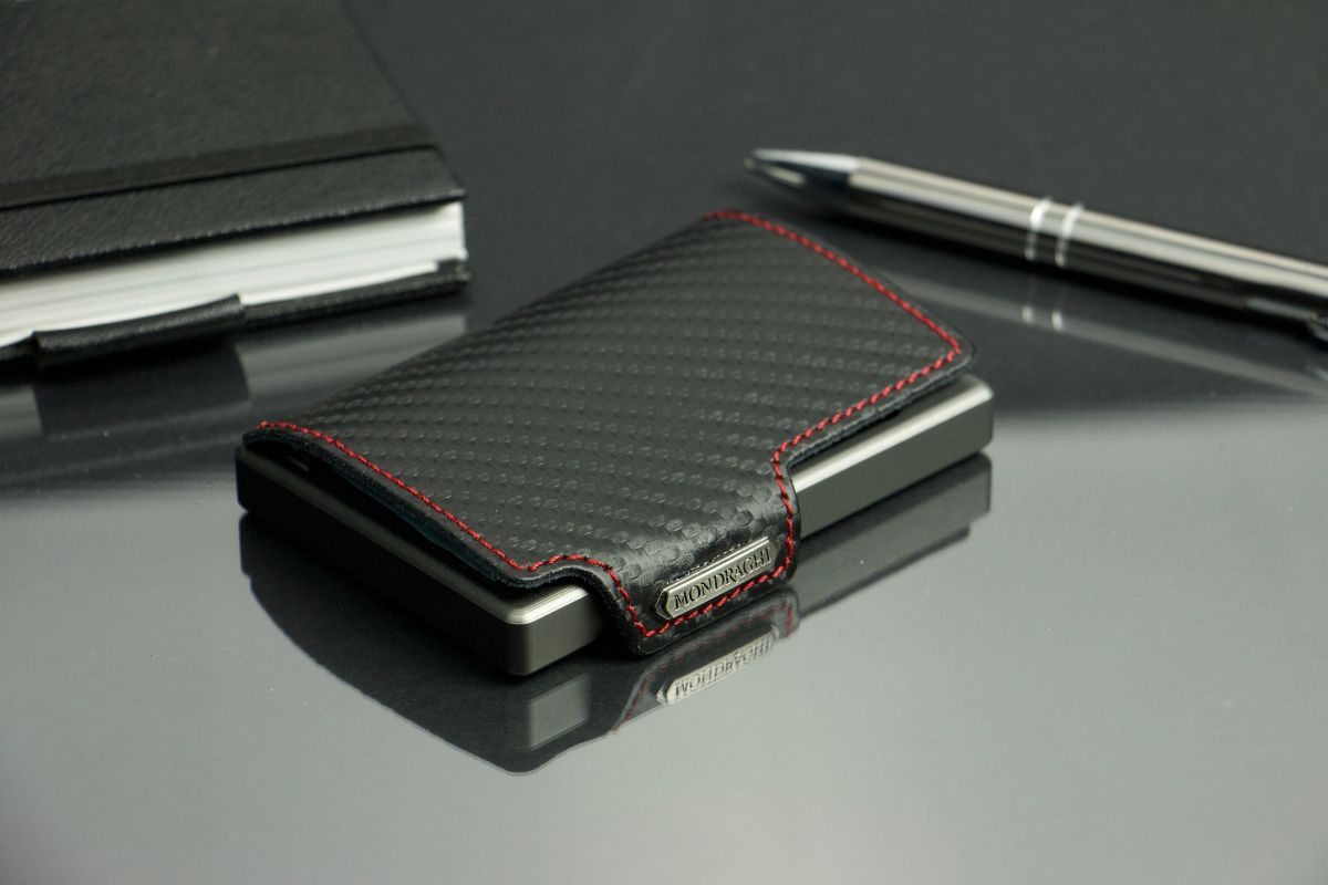 “A mini wallet resting on a table alongside a notebook and a pen